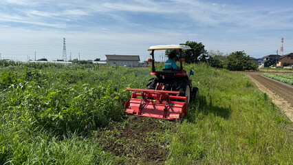 トラクターで草の畑を耕す