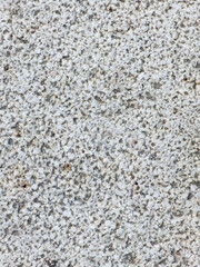 Close-up texture of light gray rough granite stone surface