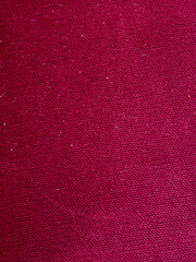 Close up of textured red fabric background with detailed weave pattern