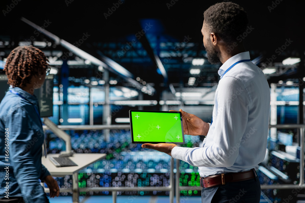 Poster data center programmer on industrial platform using green screen tablet, solving optimization tasks 