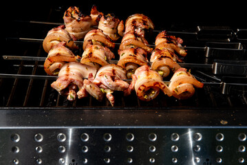 Grilled pork belly skewers cooking on barbecue grill
