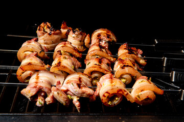 Grilled pork belly skewers cooking on barbecue grill