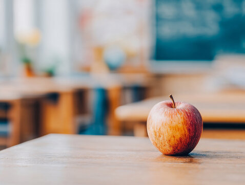 Apple on wooden table in classroom representing Back to school concept  