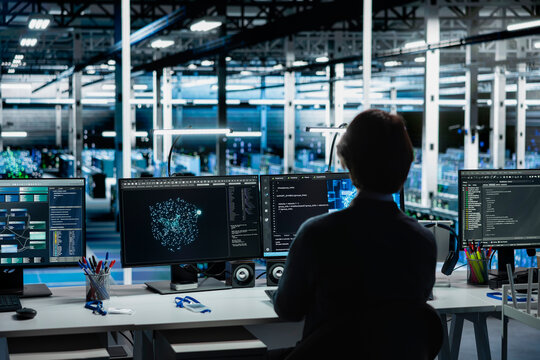 Engineer monitoring AI LLM visualization in data center with rows of operational server racks. IT expert using PC to oversee rigs powering deep learning in server hub built for digital storage systems