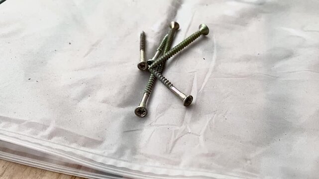 Heap of screws arranged neatly on work surface, tools for various construction tasks. Fasteners contribute to durability and stability of projects in home repairs and renovations