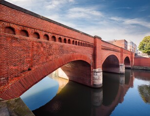 Fototapeta premium red brick arch bridge spanning urban canal