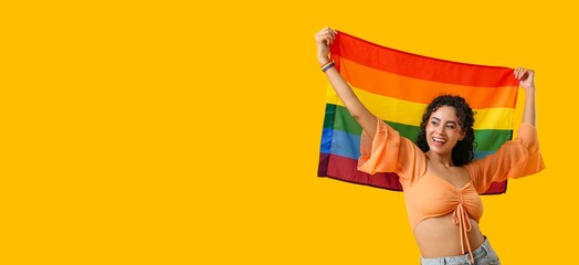 Happy African-American woman holding LGBT flag on yellow background with space for text