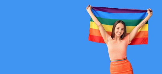 Happy young woman with LGBT flag on blue background with space for text