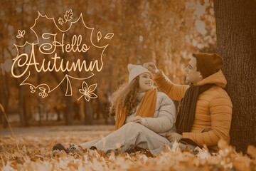 Happy couple sitting in park. Hello Autumn