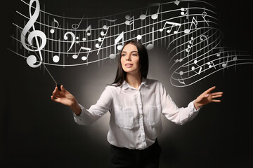 Young female conductor on dark background
