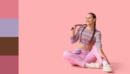 Young woman with African braids sitting on pink background. Different color patterns