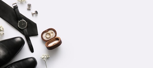 Box with wedding rings, male shoes, neck tie, cufflinks and wrist watch on white background with...