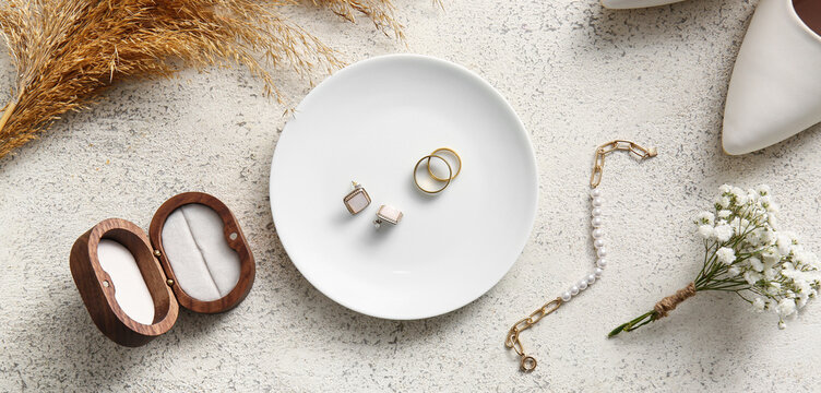 Wedding rings and cufflinks in plate on white background. Top view