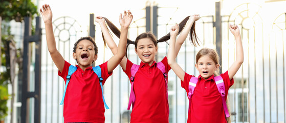Fototapeta premium Happy little pupils near school outdoors