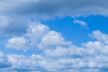 Sun shining through the puffy clouds. Sky view. Beautiful sunny sky.