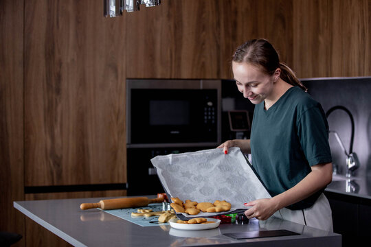 Young woman is making cookies in her kitchen