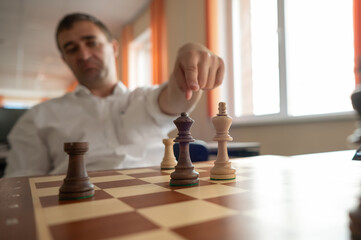 Middle aged Caucasian man playing chess. 