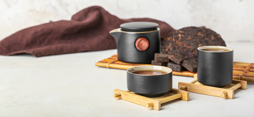 Stands with cups of puer tea on white background, closeup
