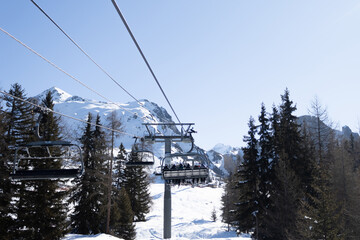 Cable car or fanicular moving against the background of winter forest, snow-covered mountains and...