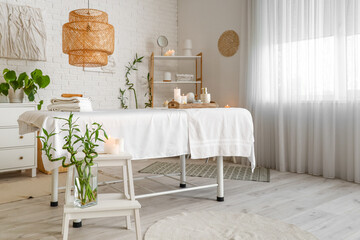 Interior of spa salon with couch and burning candles