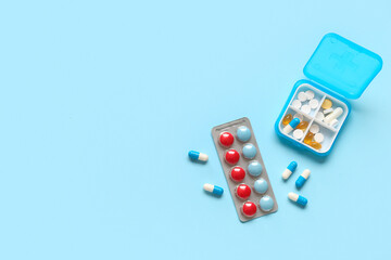 Plastic container and blister pack with pills on color background