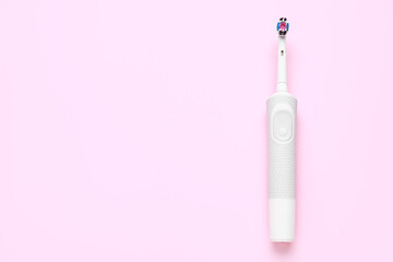 Modern electric toothbrush on pink background. World Dentist Day
