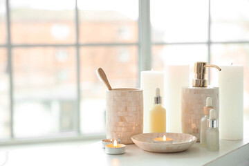 Toothbrushes, candles and different cosmetics on white bathtub tray