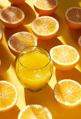 Orange fruit and glass orange juice on a orange back