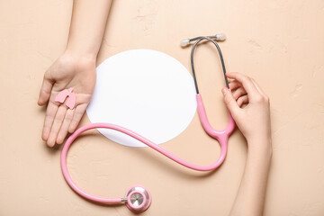 Female hands with paper lungs, stethoscope and blank card on beige background