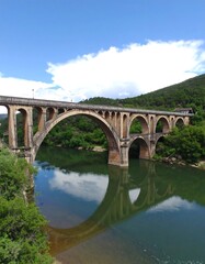 Fototapeta premium Stone arch bridge over a calm river