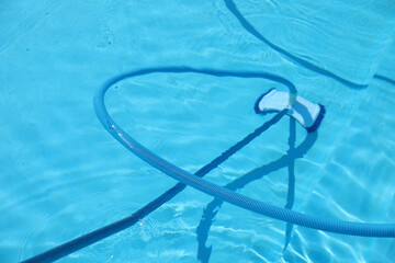 Cleaning outdoor pool with underwater vacuum, closeup