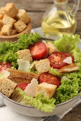 Delicious salad with croutons served on table, closeup