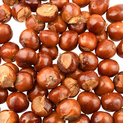 Obraz premium An abundant scattering of fresh, raw chestnuts, displaying their rich brown shells and natural textures against a clean white background, ideal for autumn food concepts