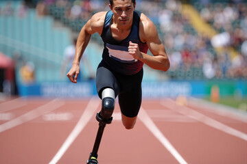 Determined athlete with a prosthetic leg powerfully sprinting on a red track during a competition, embodying resilience, strength, and overcoming adversity in sports