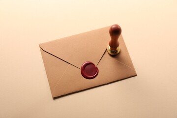 Beautiful wax stamp and envelope with seal on beige background, above view