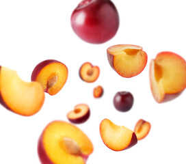 Fresh ripe plums swirling in air against white background