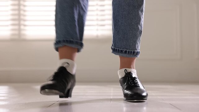 Teenage girl in tap shoes dancing indoors, closeup