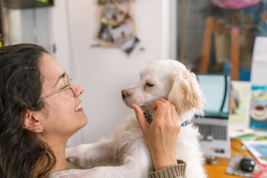 Graphic designer relaxing with her dog in home office