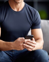 Person texting, using mobile device. Man in dark blue shirt, jeans. Technology, connection, lifestyle, communication concepts. Focusing hands, cell phone, person. Modern, contemporary, indoor,