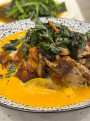 Roast duck curry with crispy skin and fresh herbs in creamy sauce