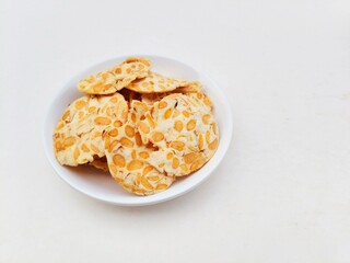 Tempeh chips in a white plate on a white background.