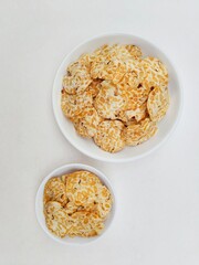 Tempeh chips in white plates on white background.