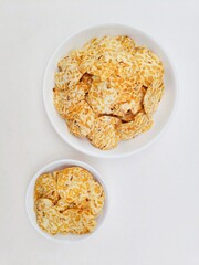 Tempeh chips in white plates on white background. Top of view. 
