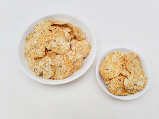 Tempeh chips in white plates on white background.