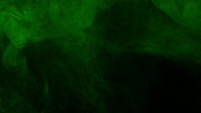 Subtle and soft green fog or smoke drifts slowly across dark screen. Atmospheric overlay for creating moody, mysterious, or eerie ambiance. For horror and fantasy