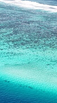 French Polynesia, Vertical Drone Shot of Coral Reefs and Ocean Waves on Lagoon Barrier
