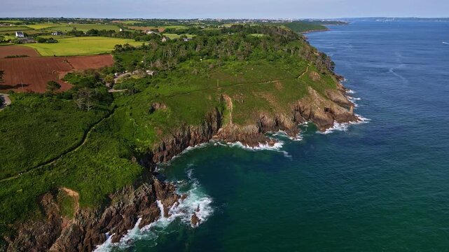 High-altitude backward drone movement from the Plouzan&eacute; shoreside near Phare du Petit Minou, Finist&egrave;re, France.