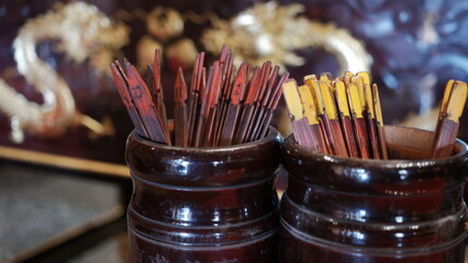 A tube of bamboo sticks is used to obtain answers from the verses written on the fortune paper....