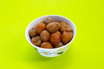 Pickled plums on green background.