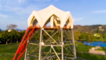 Blurry outdoor structure with a large, white, multi-faceted roof